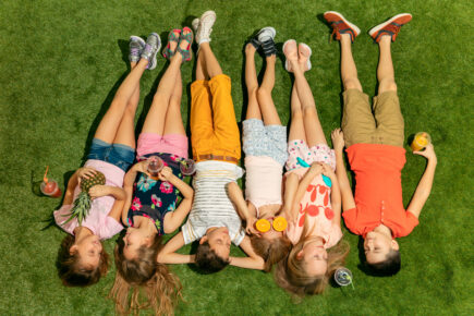 Grupa dzieci leżących na trawie