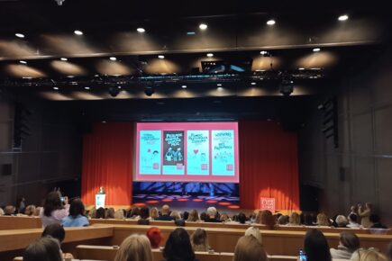 Sala konferencyjna z prezentacją wyświetloną na ekranie